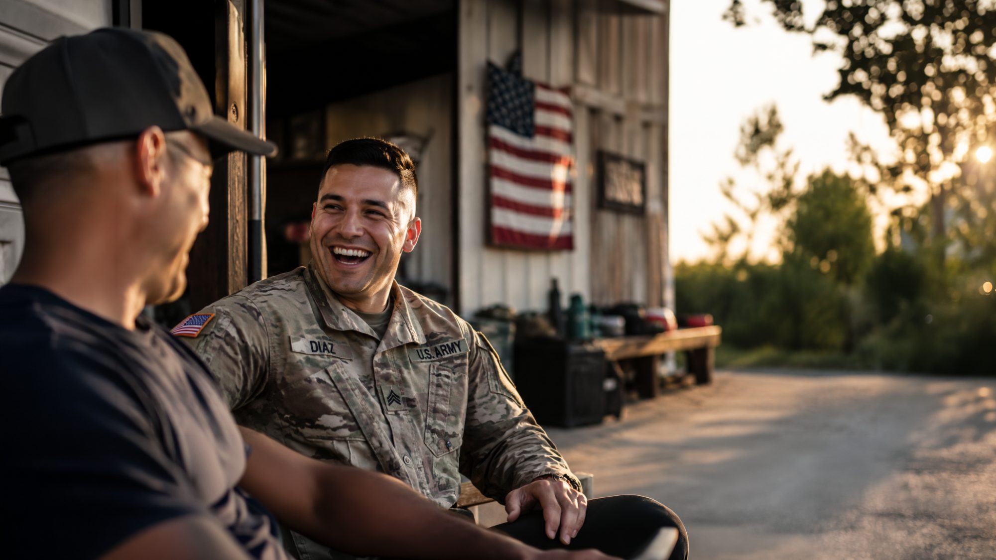 A U.S. Army sergeant laughing with a friend outside at sunset